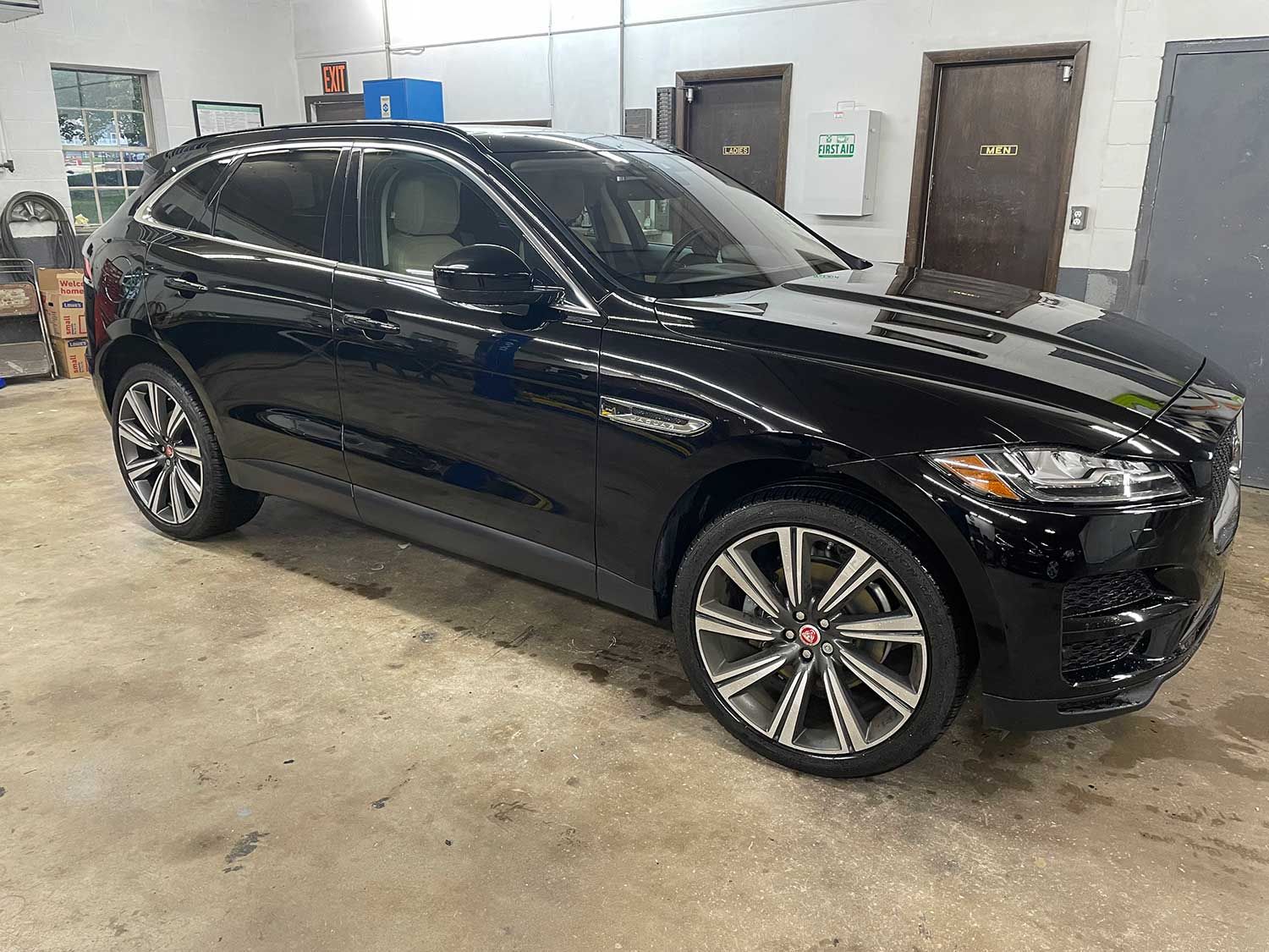 Black Jaguar SUV parked inside a garage.
