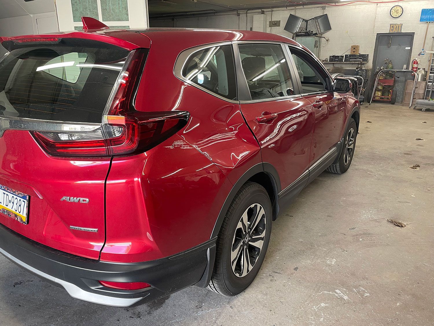 Red Honda CRV SUV parked inside a garage.