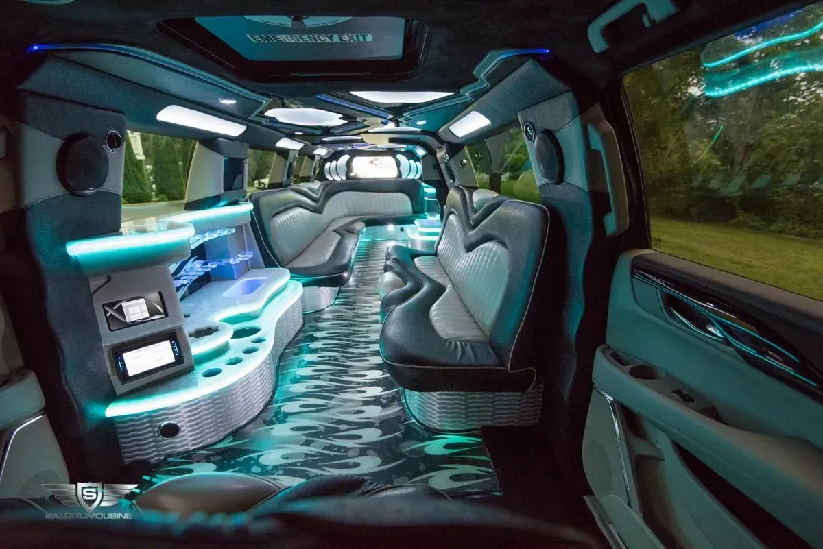 Inside of a luxury limousine with blue and white interior, built-in lighting and seating.