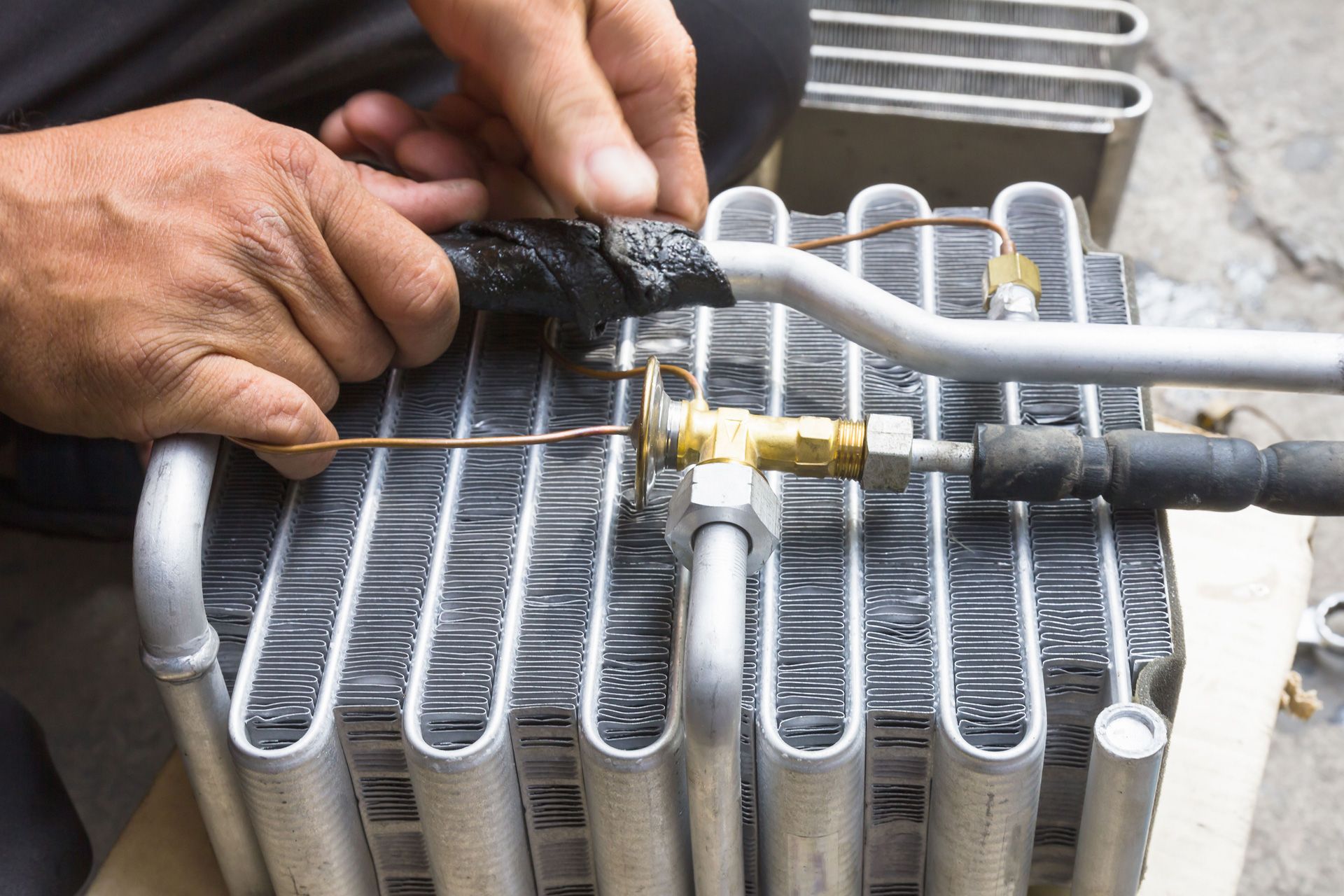 a man is working on a radiator with a hose attached to it