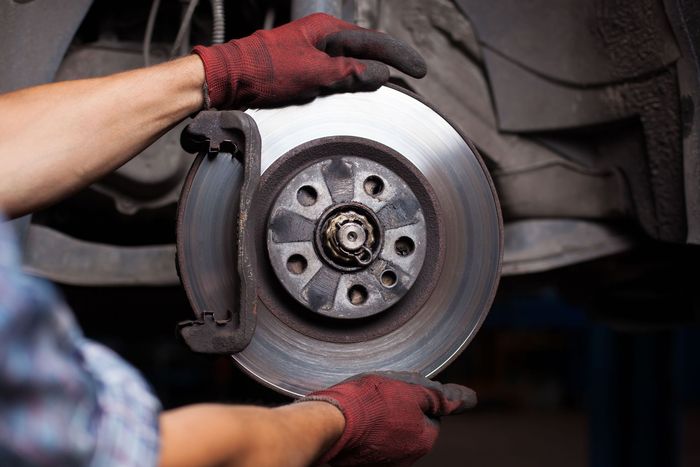 a person is fixing a brake disc on a car