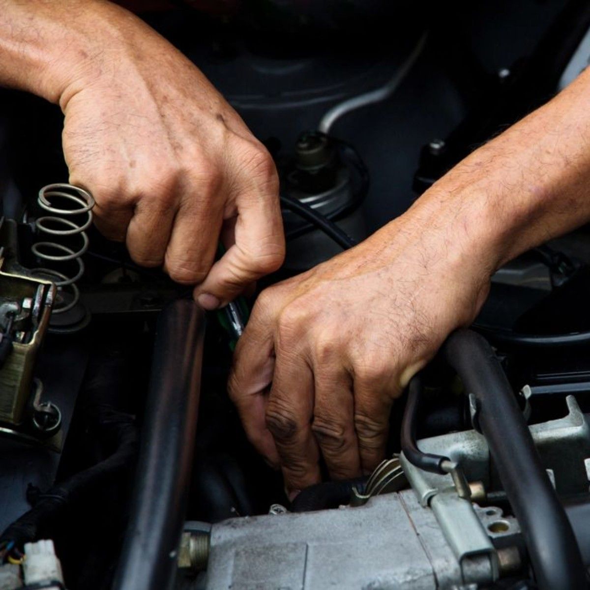 a close up of a person working on a car engine