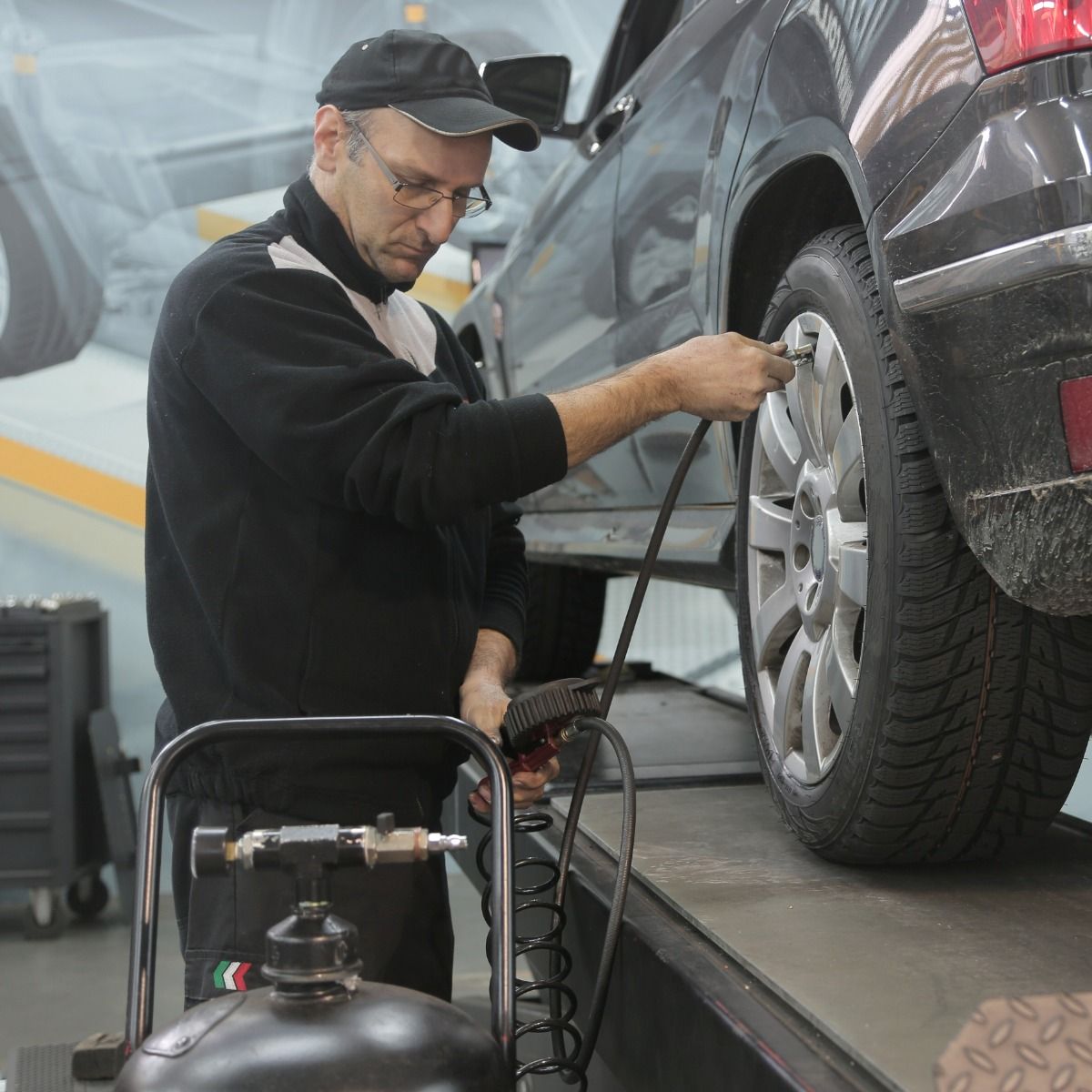 a man is working on a car tire in a garage
