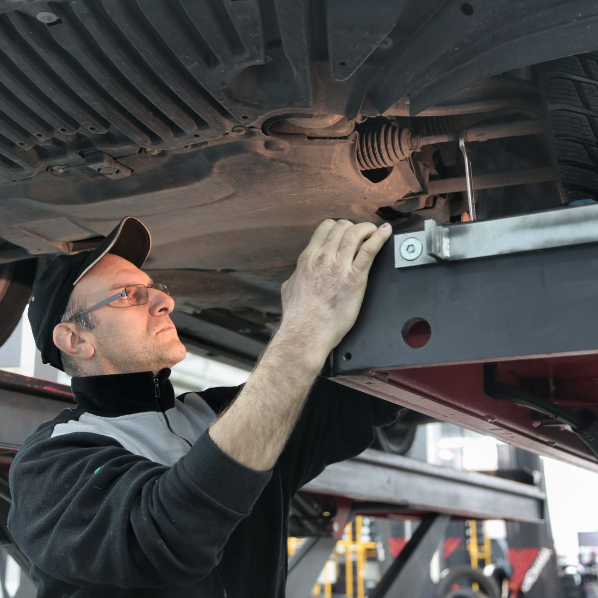 a man is working under a car on a lift
