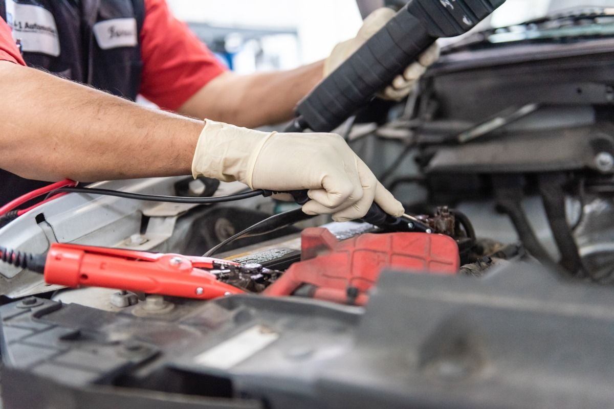 a man is charging a car battery with a jump starter