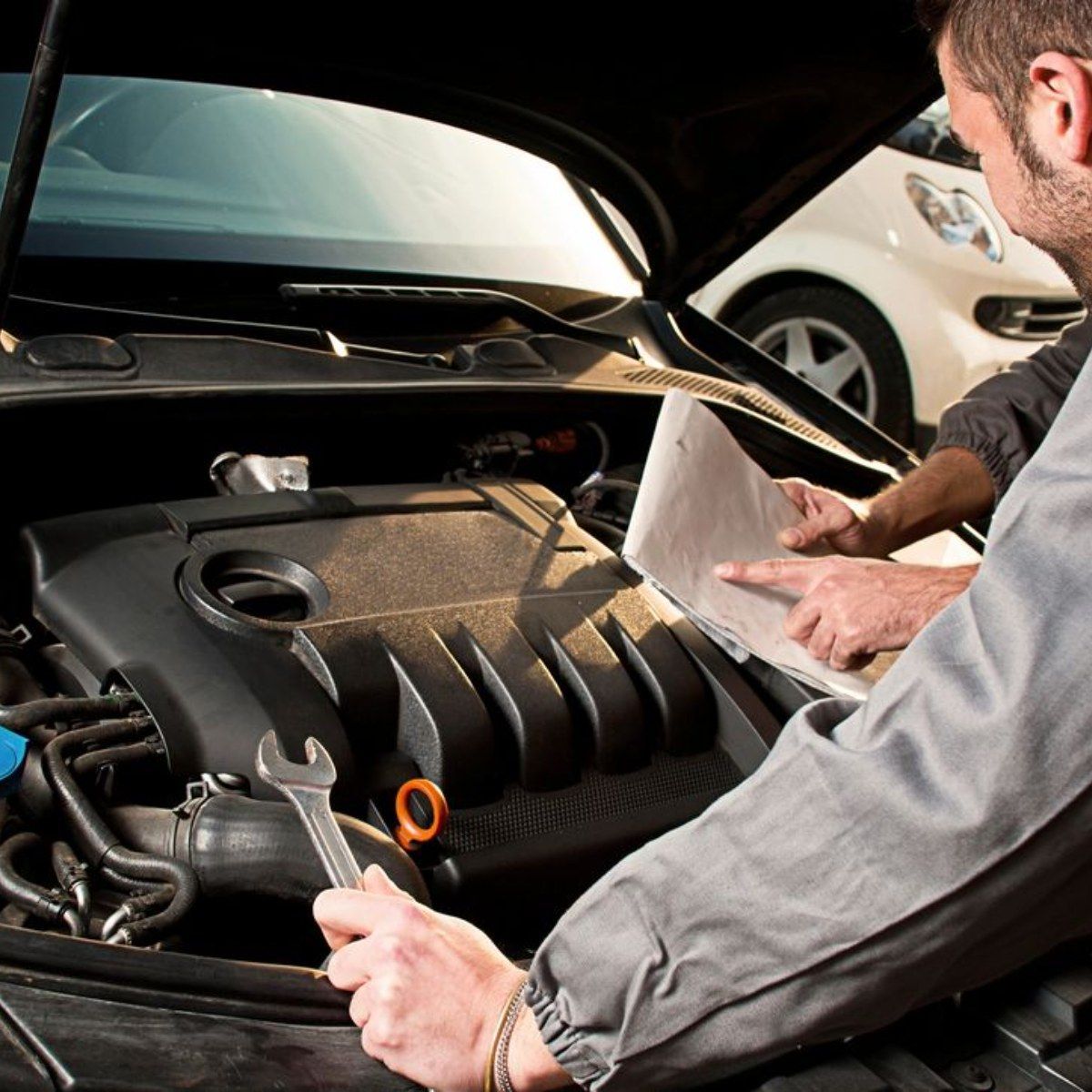 a man is working on the engine of a car