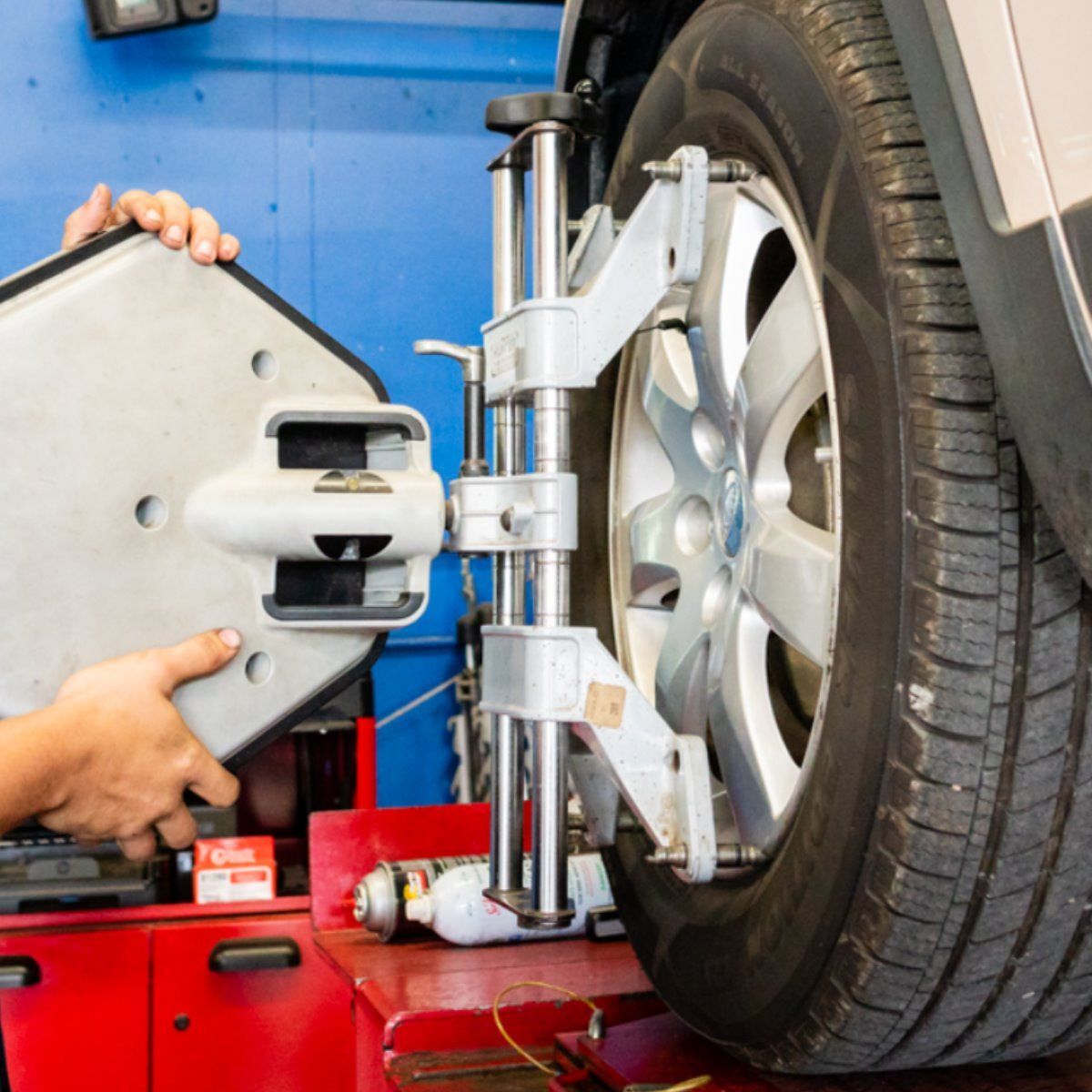 a person is adjusting a car wheel with a machine