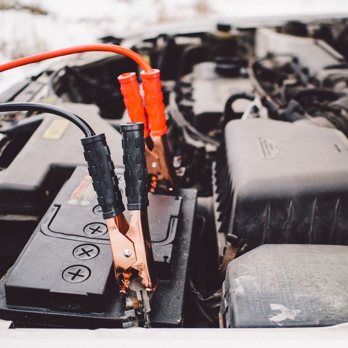 a close up of a car battery with jumper cables attached to it