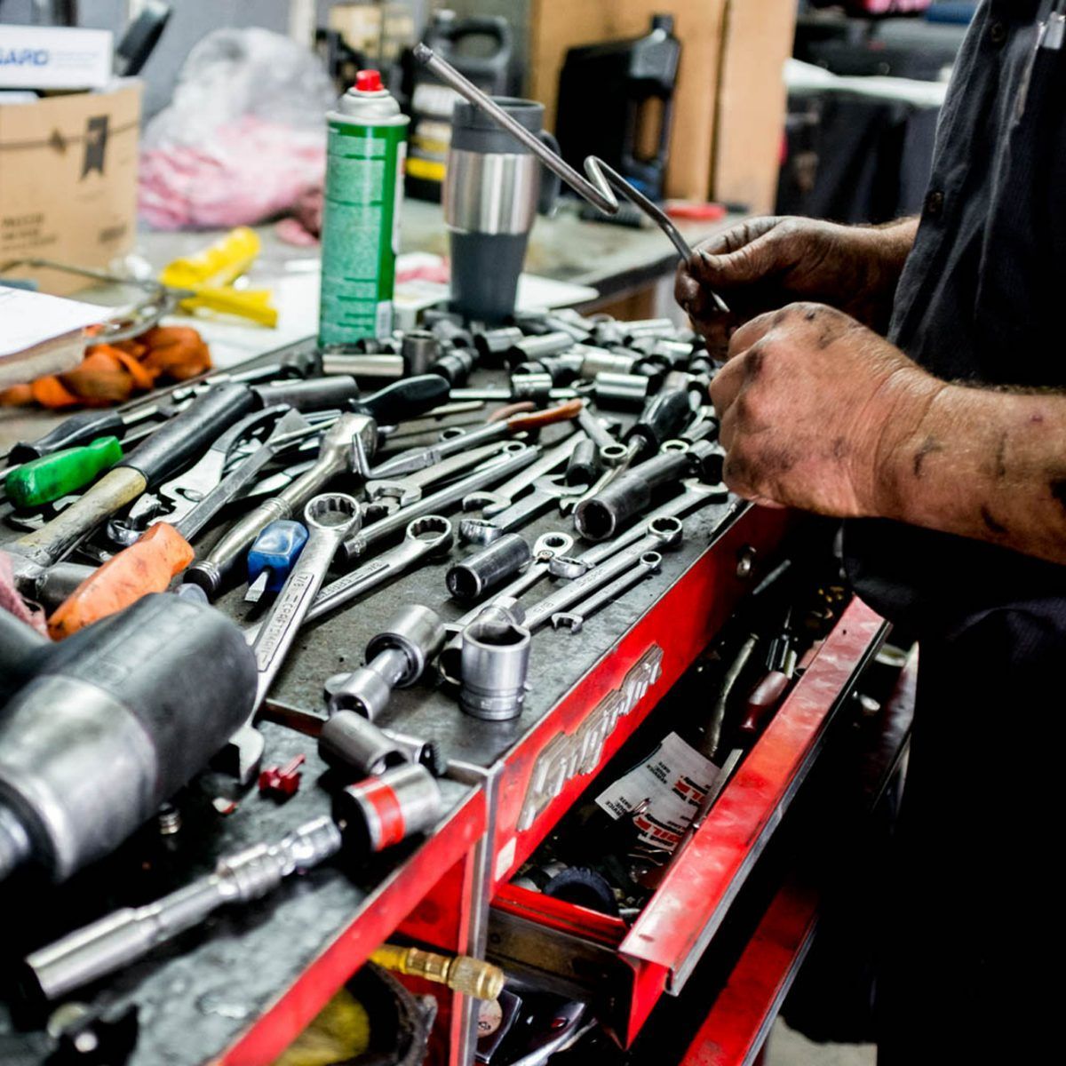 a man is working on a toolbox full of tools