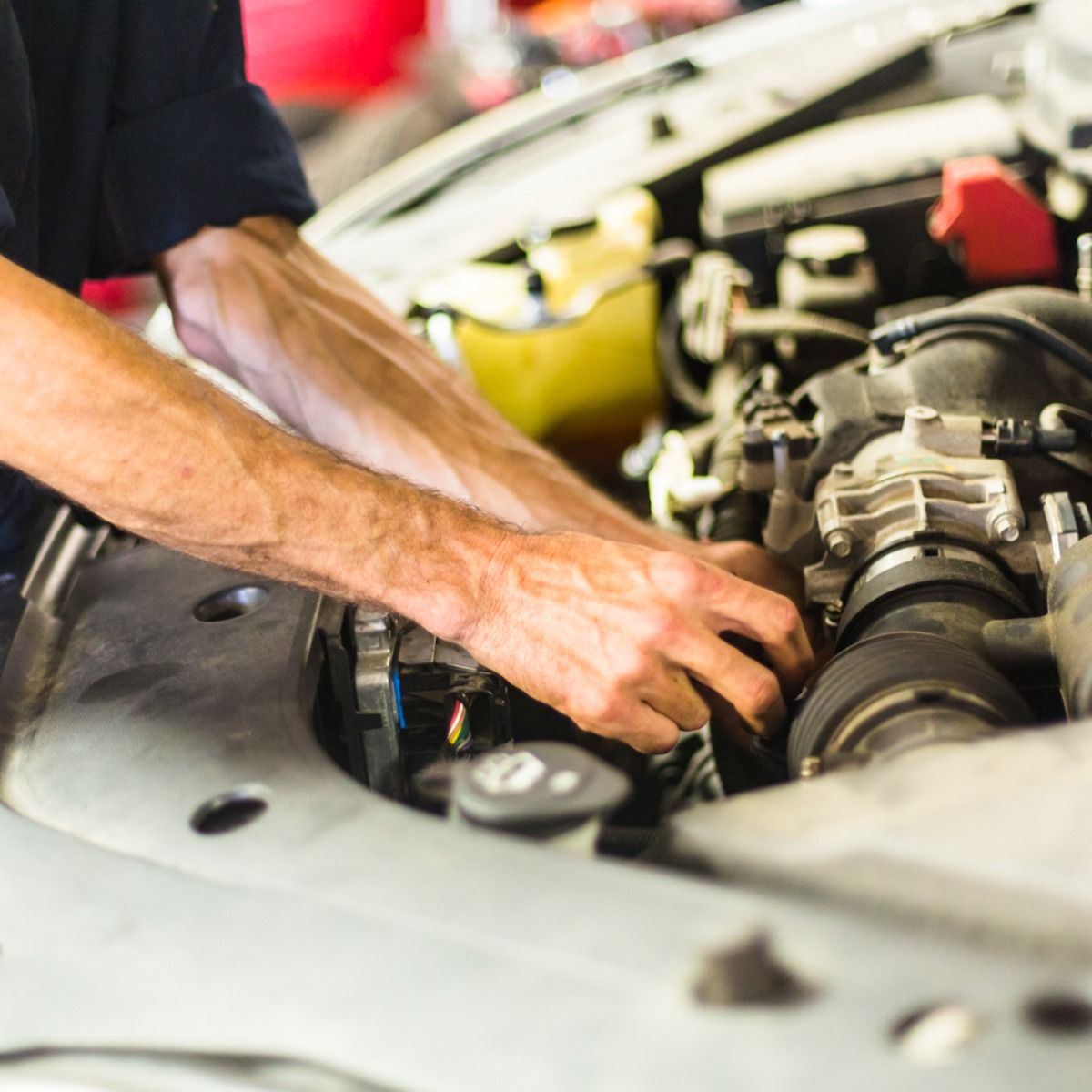 a man is working on the engine of a car