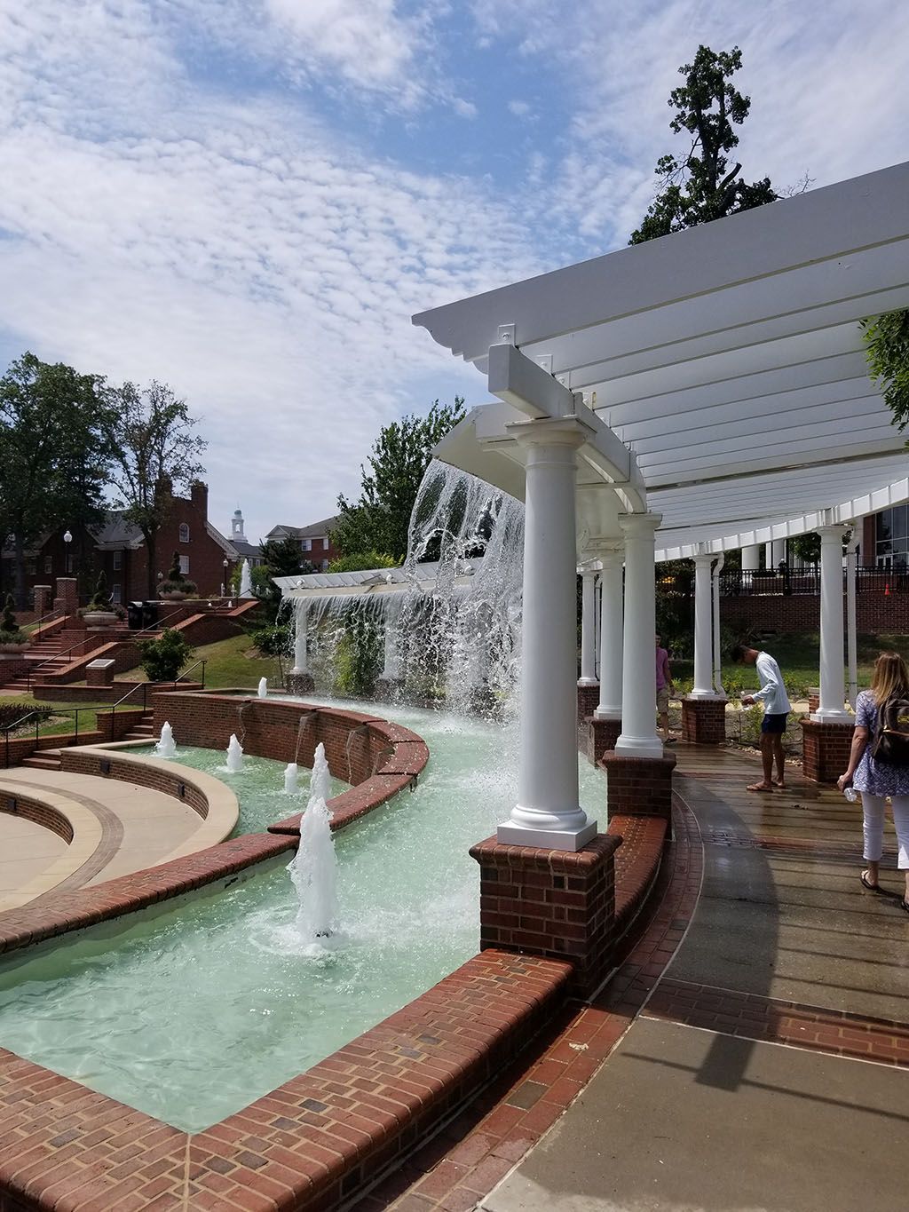 A fountain in a park with people standing around it