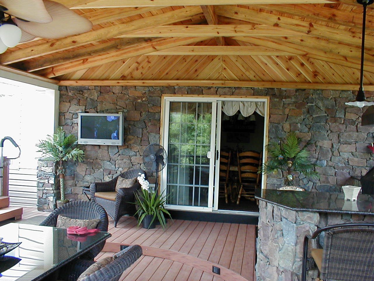 A patio with a table and chairs and a tv on the wall