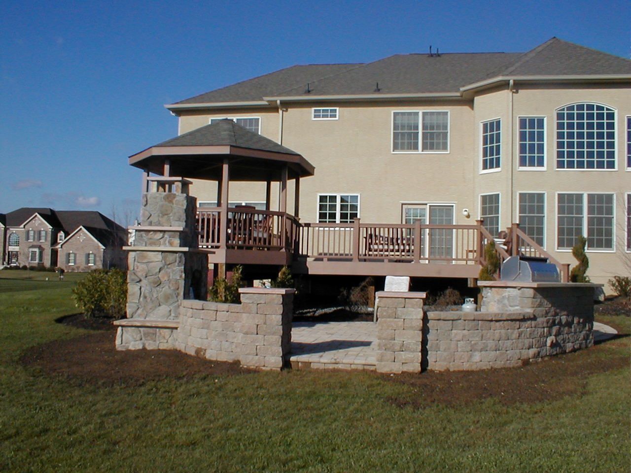 A large house with a deck and gazebo in front of it