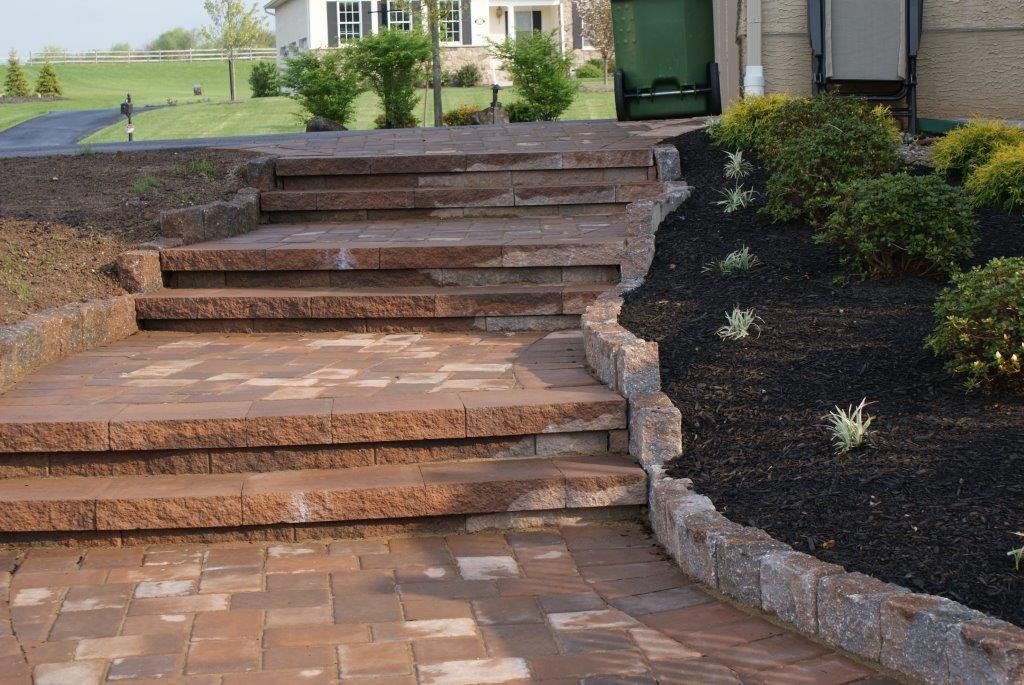A brick walkway with stairs leading up to a house