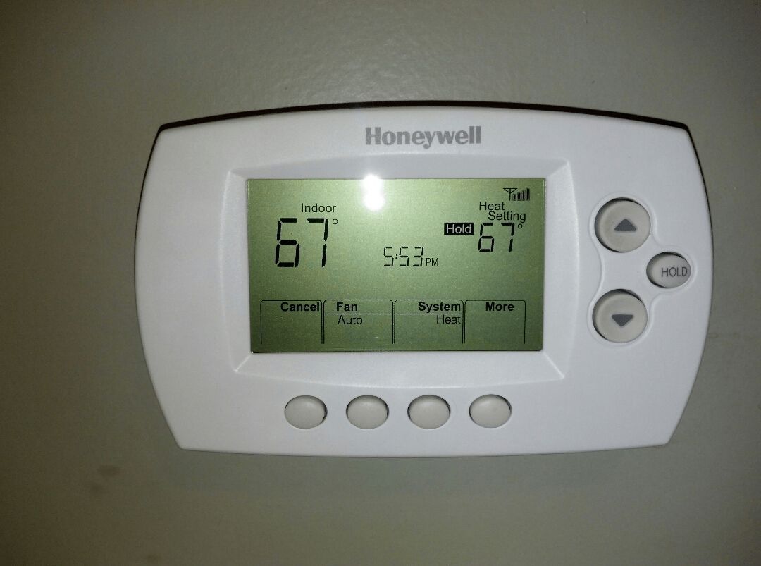 A honeywell thermostat is set to 67 degrees