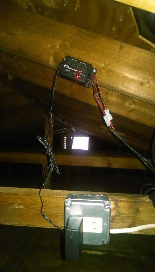 A box is hanging from the ceiling of an attic.