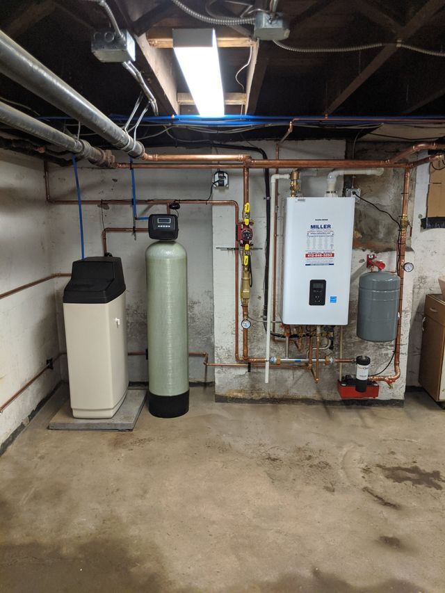A basement with a water softener and a water heater.
