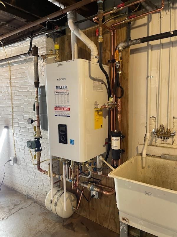 A white water heater is sitting next to a sink in a room.