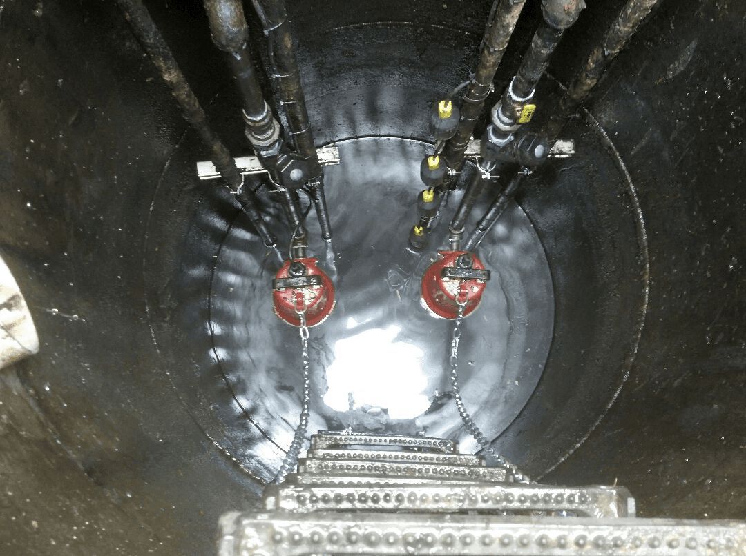 A man is standing in the middle of a well with a ladder.