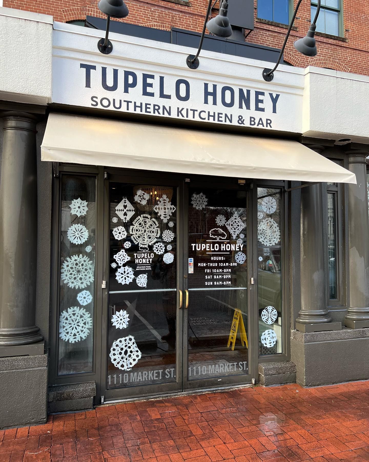 Tupelo honey southern kitchen and bar is located on a brick building.