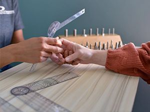 a person is measuring another person's wrist with a ruler