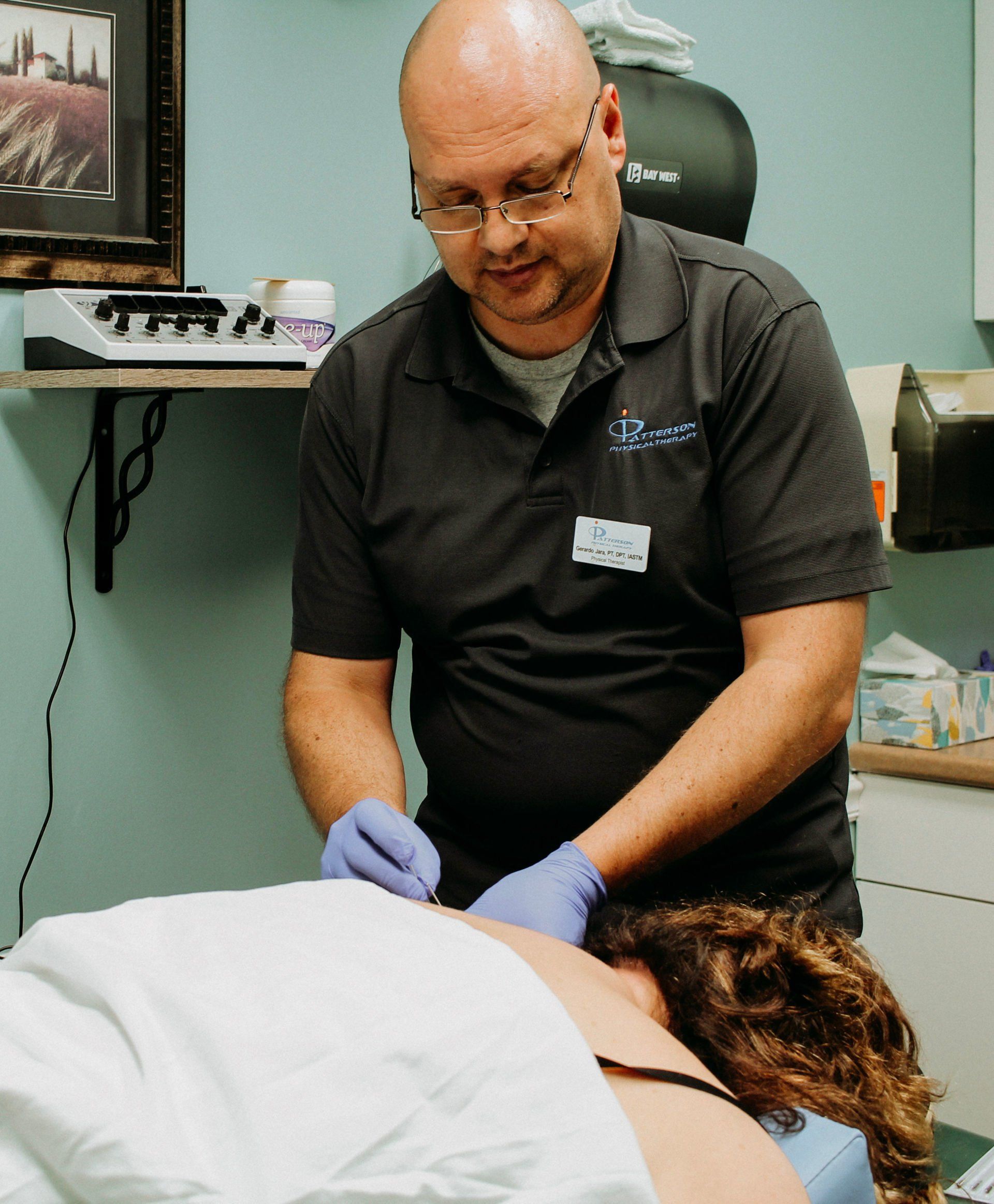 a man in a black shirt performing dry needling