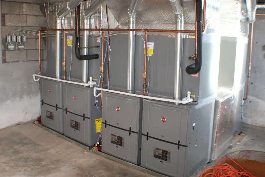 A room with a lot of heaters and pipes in it.