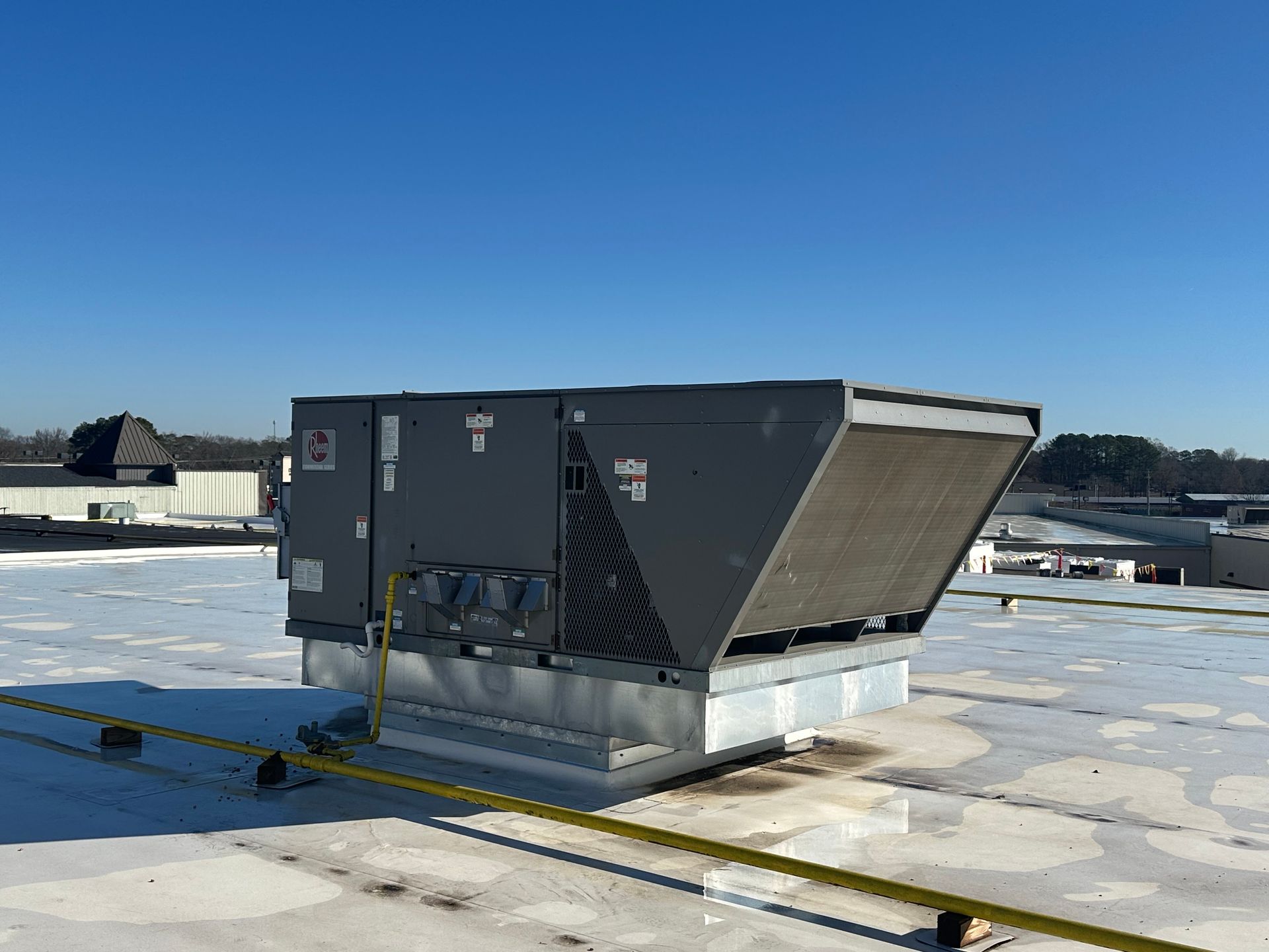 A large air conditioner is sitting on top of a roof.
