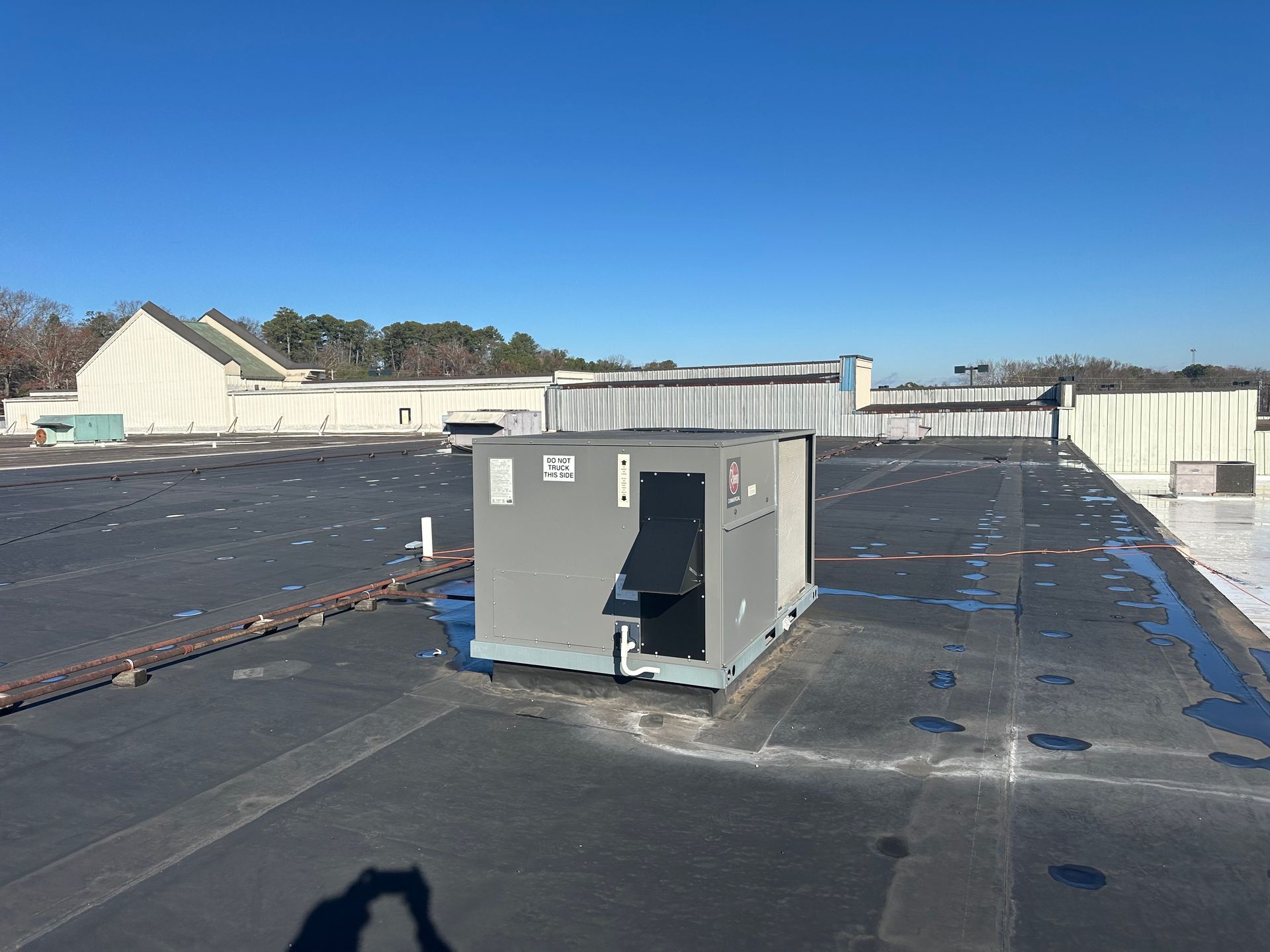 A large gray box is sitting on top of a roof.