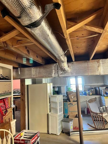 A room with a wooden ceiling and a rocking chair.