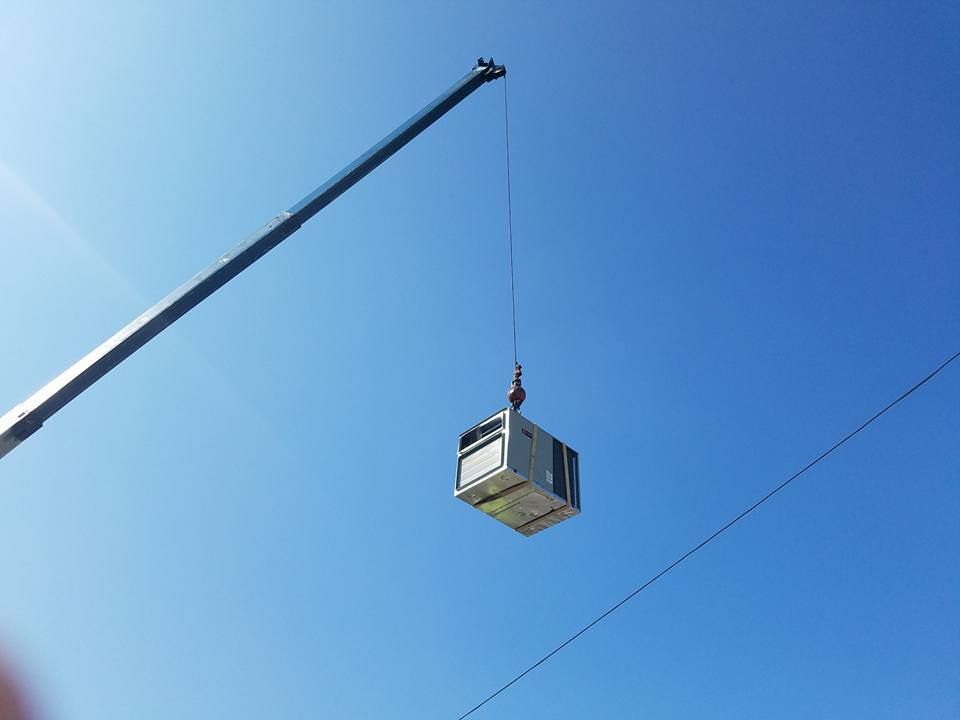 A crane is lifting a box in the air.