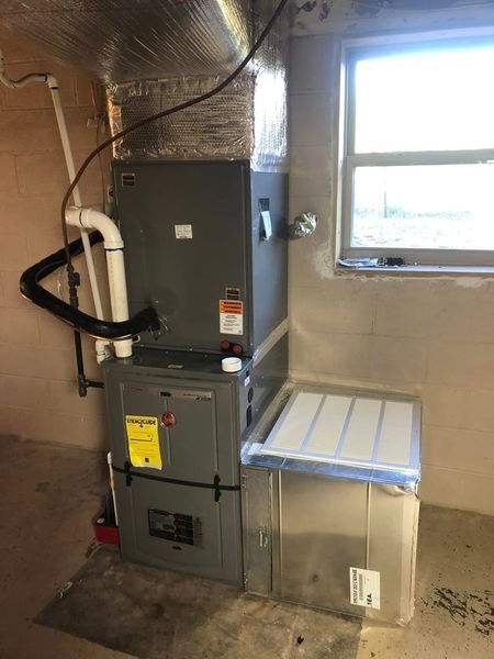 A furnace is sitting in a room next to a window.