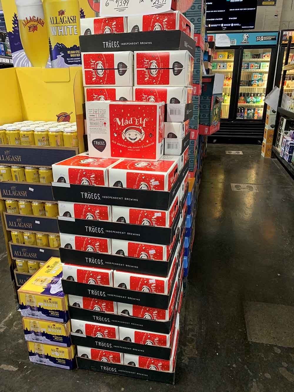 Boxes of beer are stacked on top of each other in a store