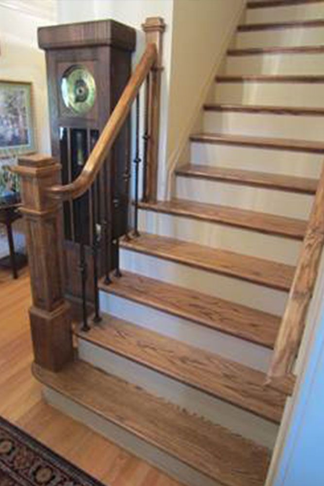 A staircase with wooden steps and a clock on the wall.