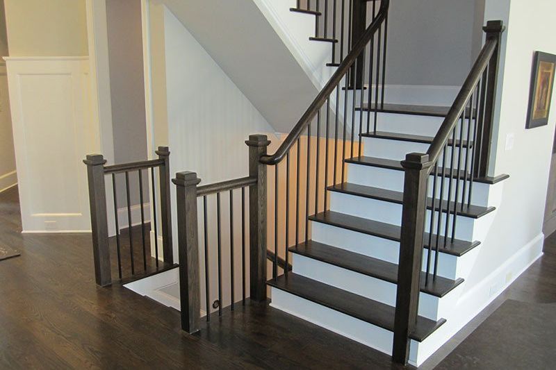 A staircase with a black railing and white steps