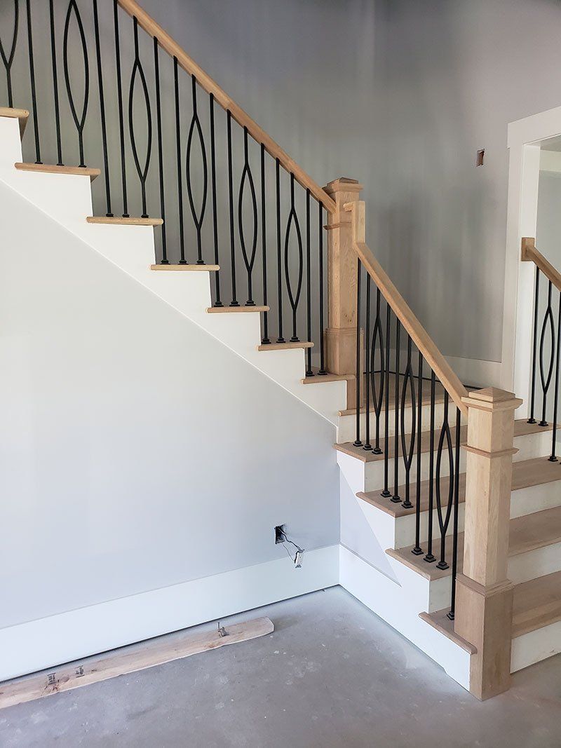 A wooden staircase with a metal railing in a room