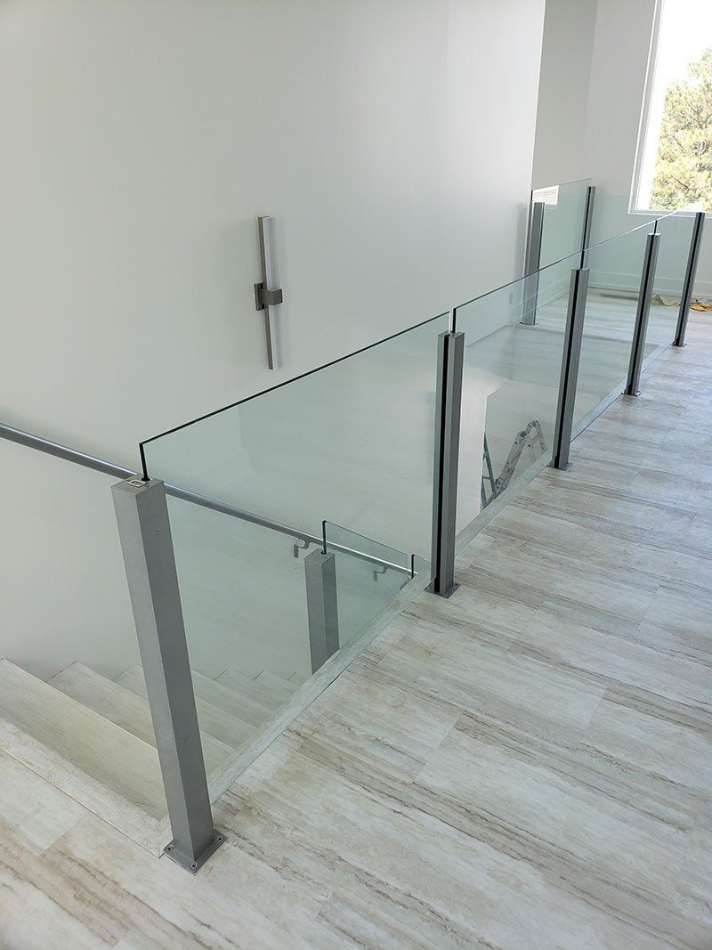 A staircase with a glass railing and a wooden floor.
