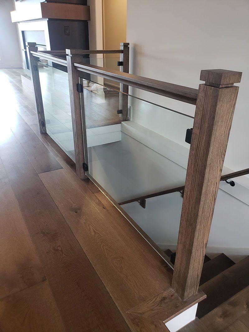 A staircase with a wooden railing and a glass railing.
