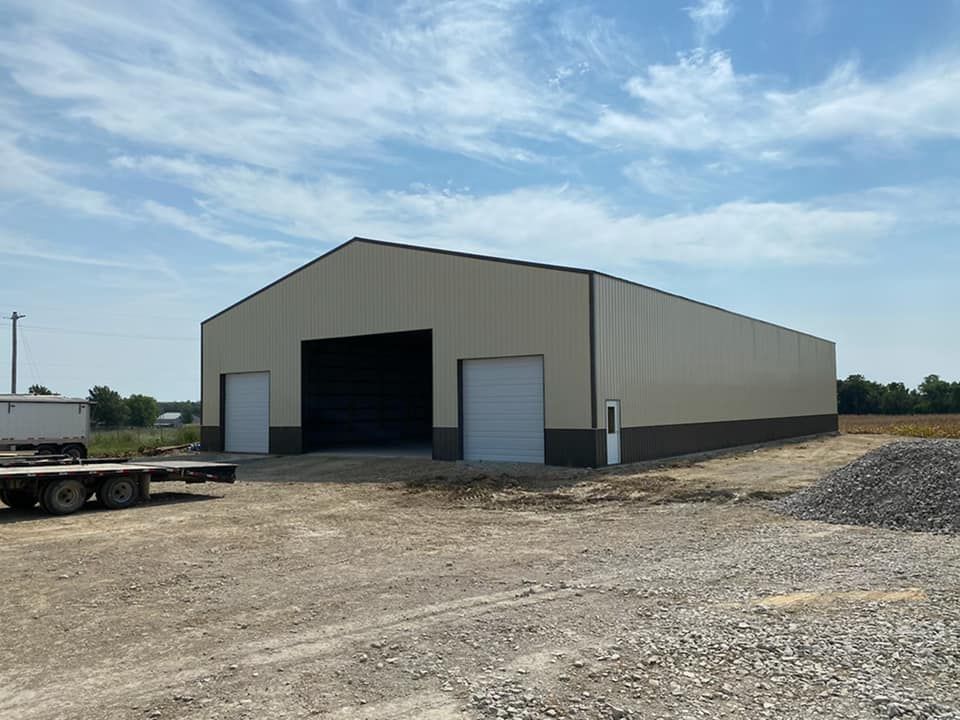 A large metal building with a trailer parked in front of it.
