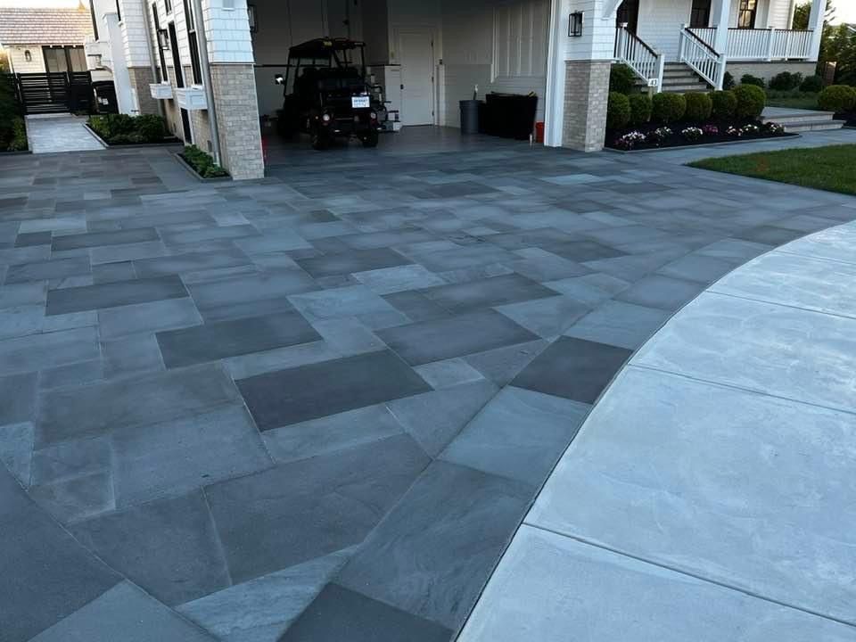 Blue stone paved driveway leading to a garage, with a golf cart inside.
