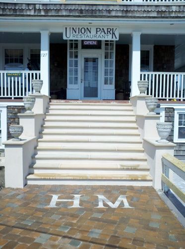Entrance to Union Park Restaurant with stairs, urns, and a brick patio with 