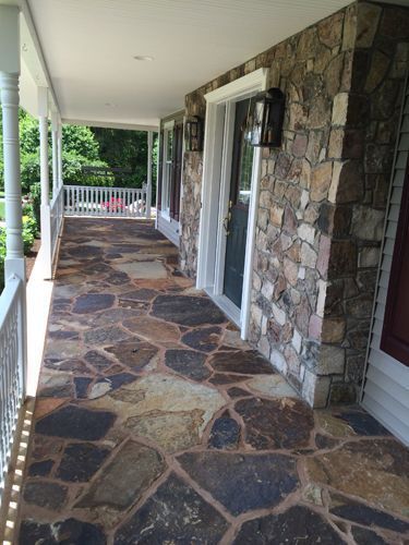 Covered porch with flagstone floor and stone wall.
