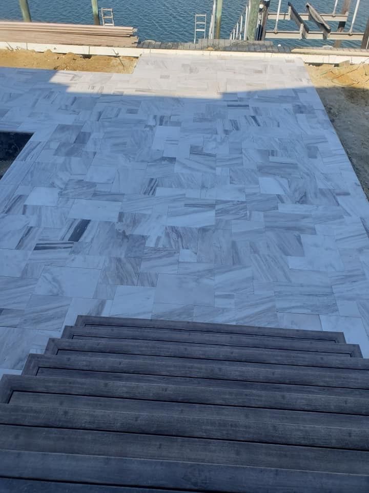 Marble patio with stairs leading down to a waterfront dock.