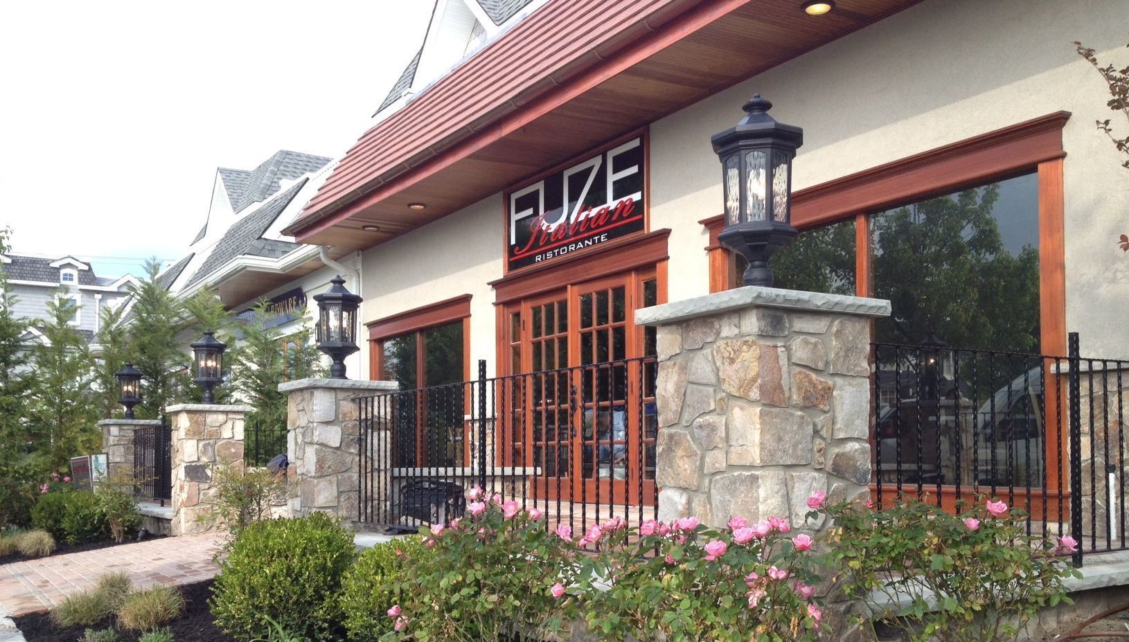 FUZE restaurant exterior with stone columns, red trim, and glass doors.
