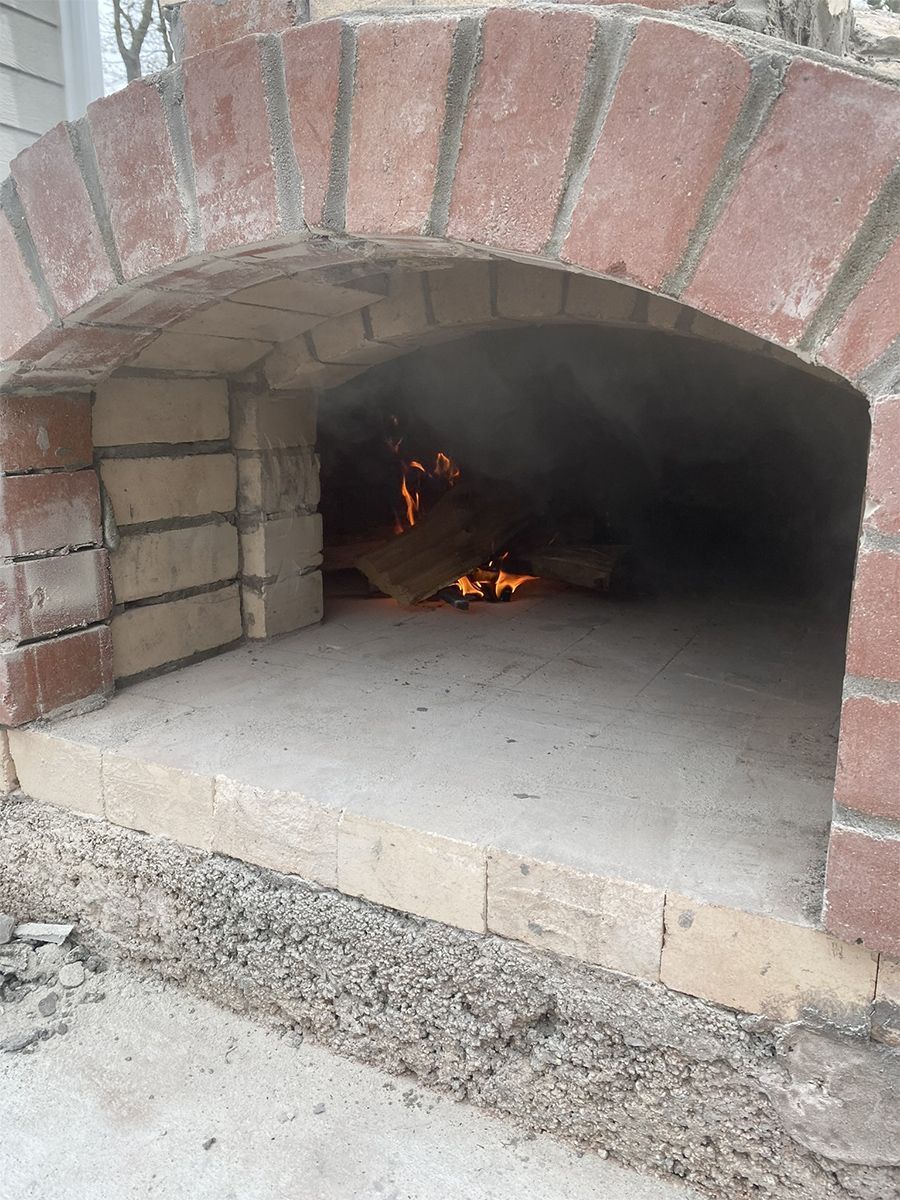 Brick oven with fire burning inside.