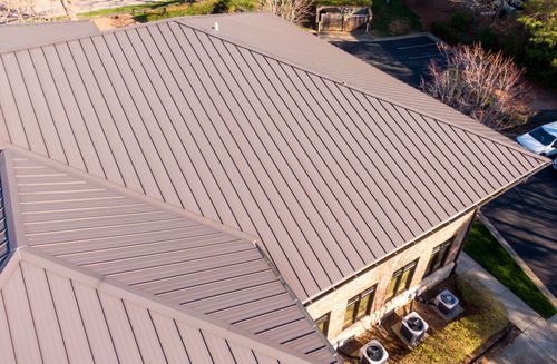 Brown metal roof on a building with multiple angles, seen from above.