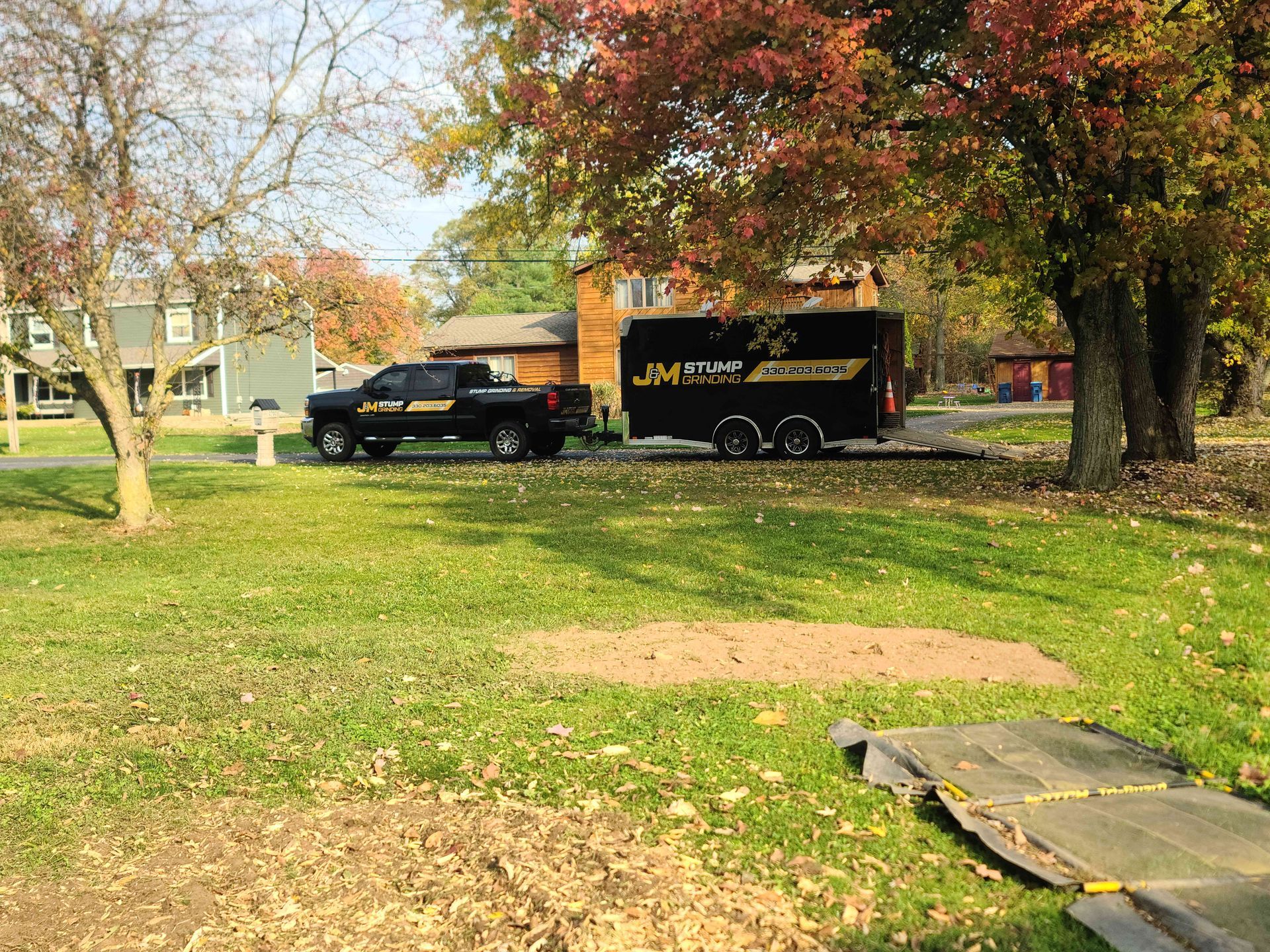 A truck and trailer are parked in a grassy field.