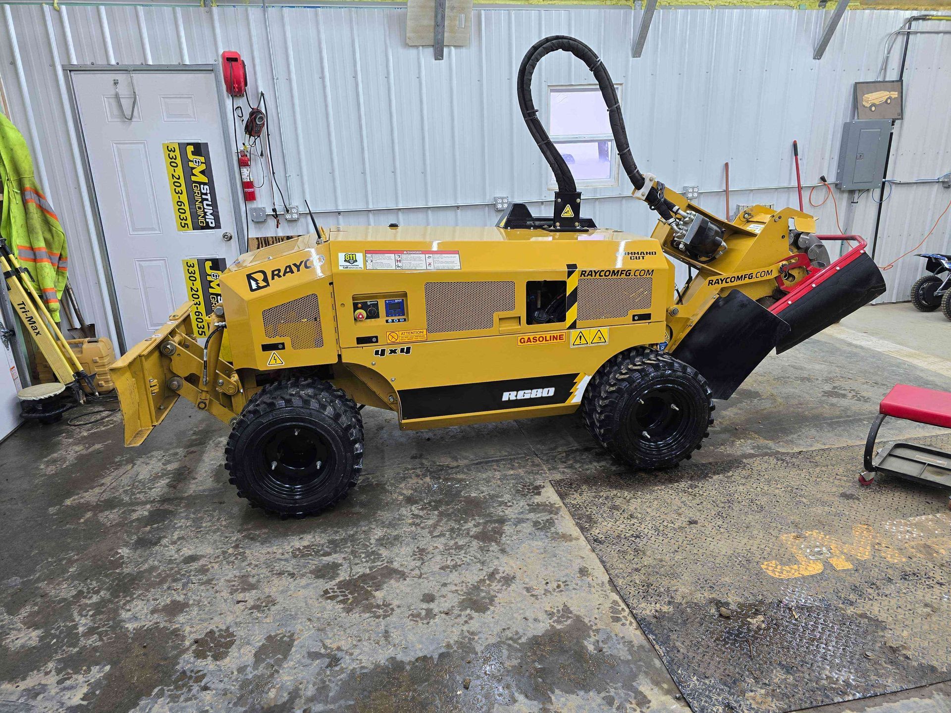 A small yellow tractor is parked in a garage.