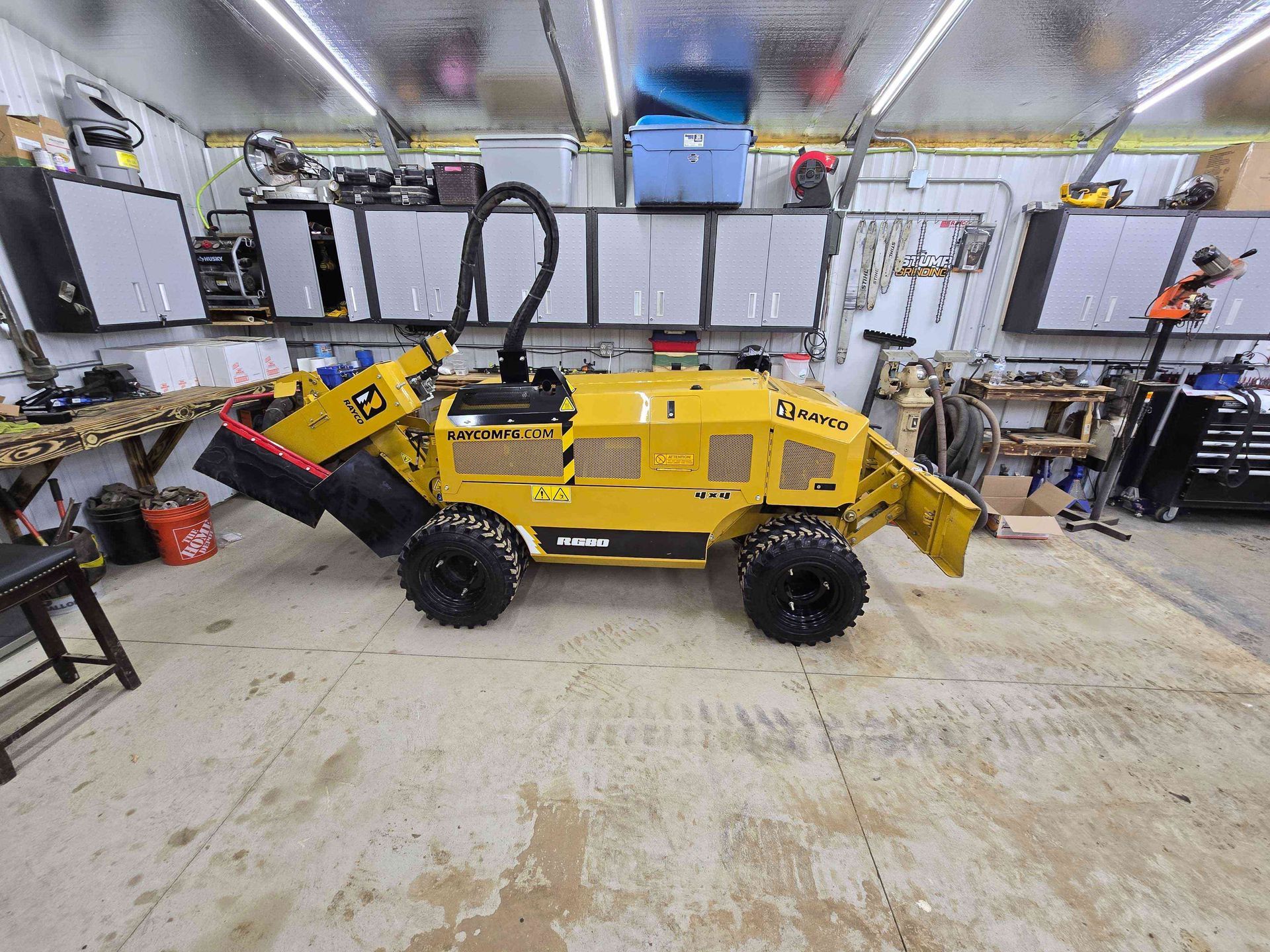 A yellow tractor is parked in a garage.