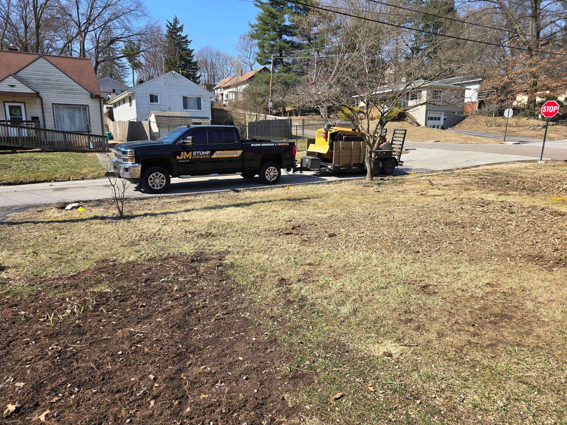 A truck with a trailer attached to it is parked on the side of the road.